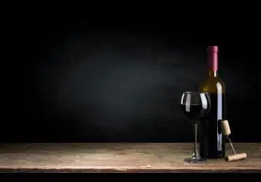 Fles rode wijn en wijnglas op tafel